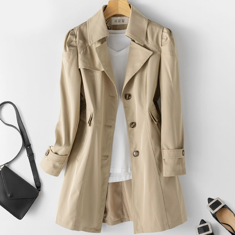 Gabardina elegante de mujer con hombros acolchados y un botón, ideal para moda de otoño y primavera.