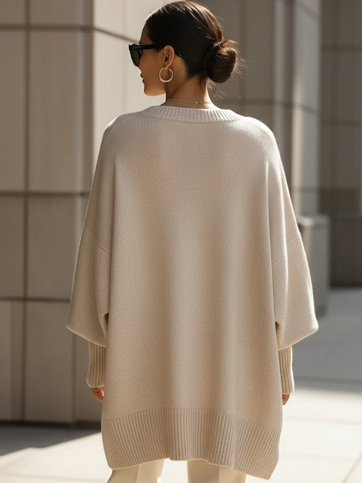 Mujer feliz usando poncho jersey oversize de algodón, calentita y con estilo en los días fríos de invierno.