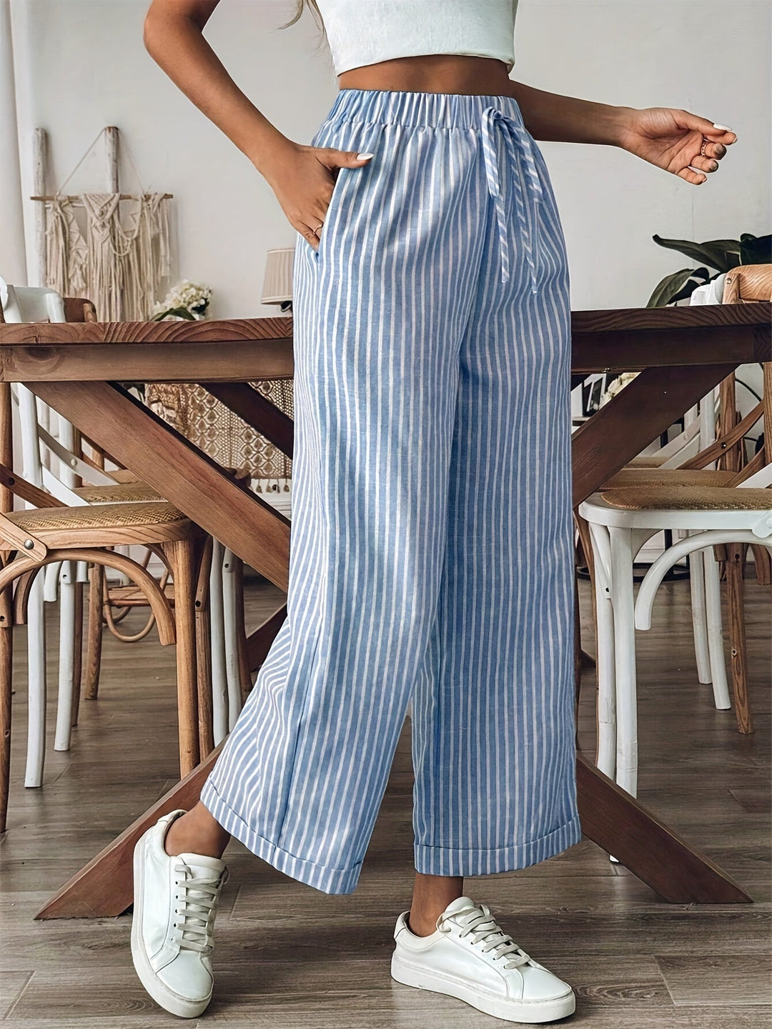 Detalle de la cintura ajustable en pantalón fluido de rayas para mujer. Estilo casual y versátil.