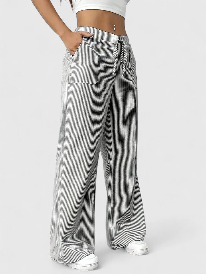 Pantalón ancho gris claro, pierna fluida y cintura ajustable. Look casual de moda femenina.