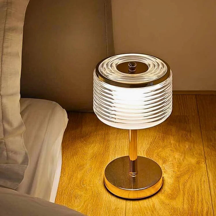 Lámpara de mesa LED Cirvella con luz blanca. Estilo moderno, vidrio y detalles dorados. Iluminación funcional y decorativa.