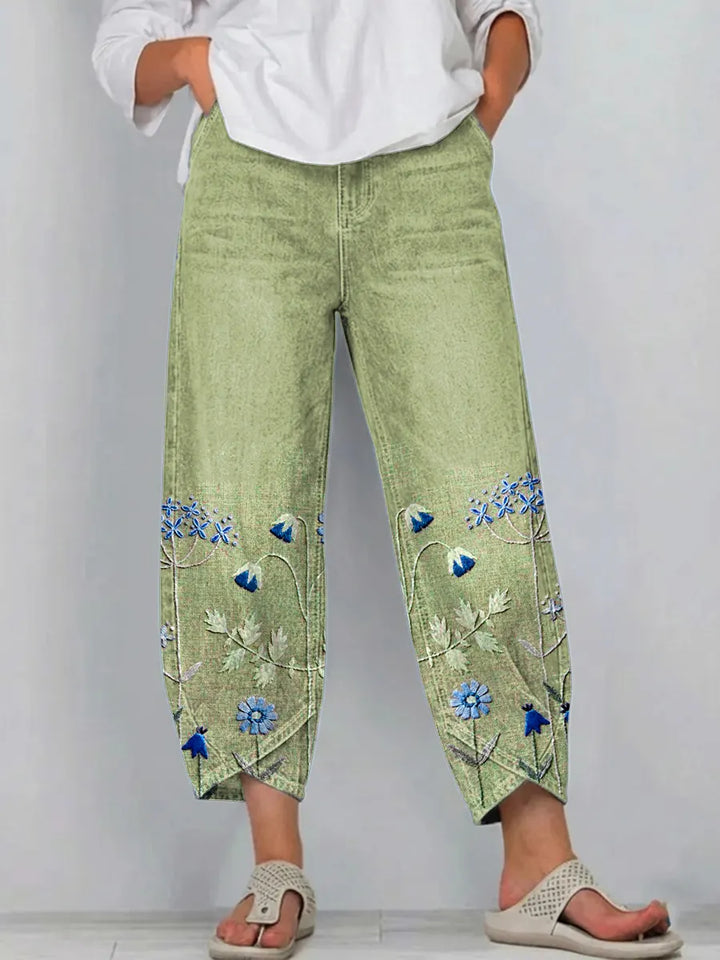 Pantalón vaquero de mujer, textura denim azul con bordado floral boho. Diseño de corte recto para confort.
