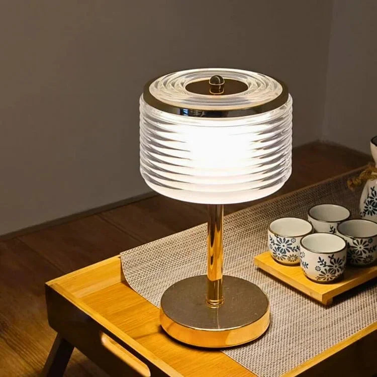 Vista detallada Lámpara de mesa LED Cirvella, resaltando vidrio, dorado y su diseño moderno. Luz neutra elegante.