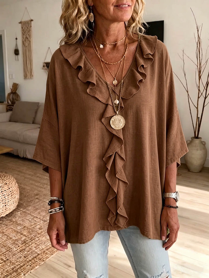 Elegante blusa casual de mujer con volantes, manga 3/4 y escote en V. Confeccionada en algodón y lino.
