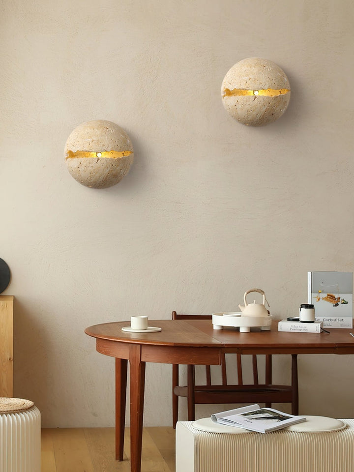 Aplique de travertino natural con luz ambiental difusa para crear atmósferas acogedoras.