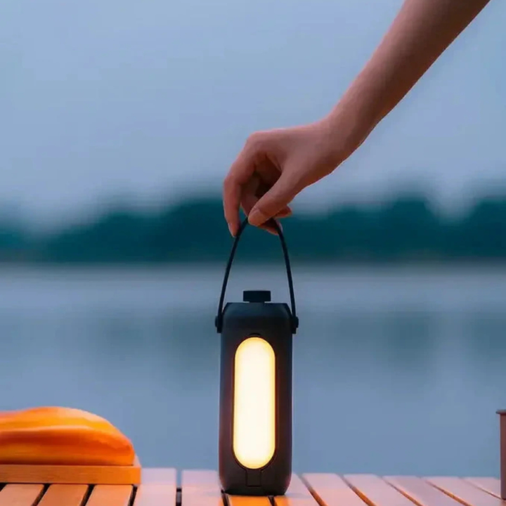 Diseño minimalista en lámpara LED portátil, recargable para exteriores, iluminación cálida.