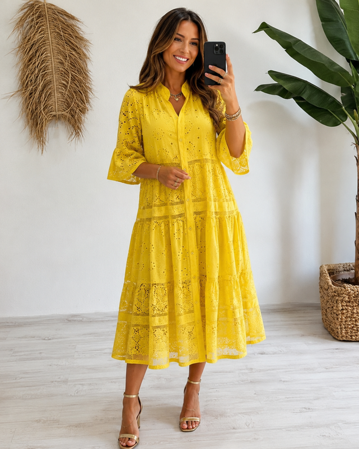 Primer plano del encaje y cierre de botones en vestido femenino con mangas acampanadas. Look de verano.