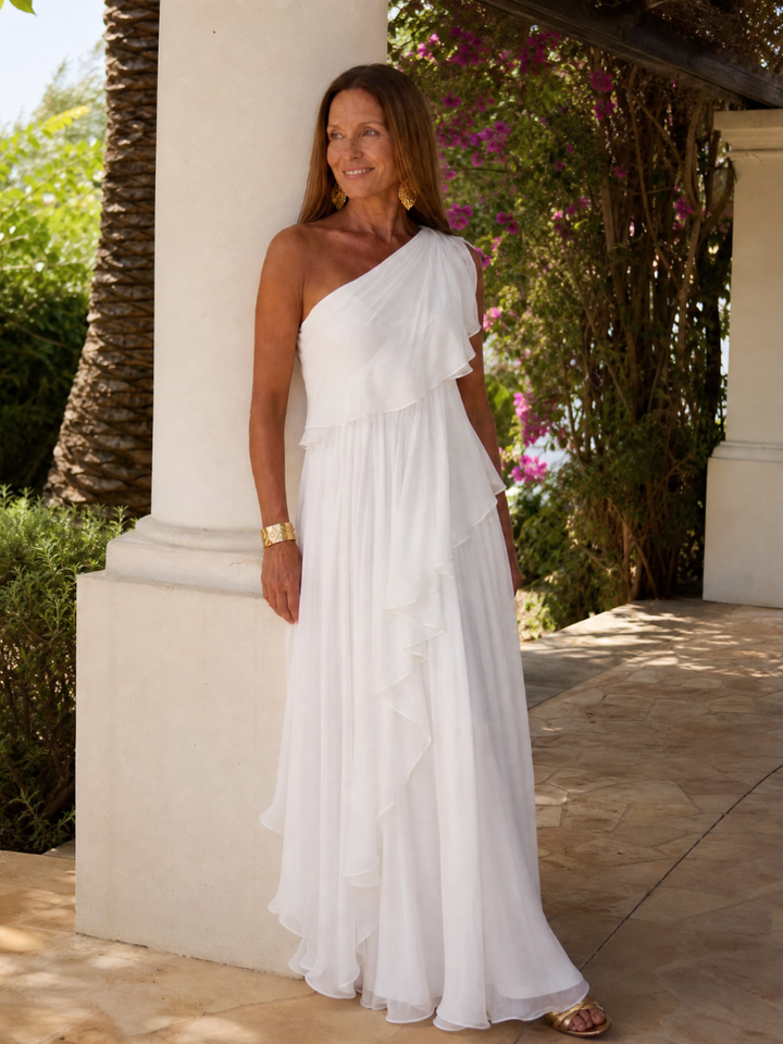 Elegante vestido asimétrico con volantes en rosa vibrante, silueta maxi para bodas o galas.