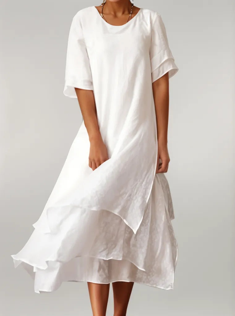Elegante vestido fluido azul de mujer con cuello redondo y manga corta, perfecto para un look versátil.