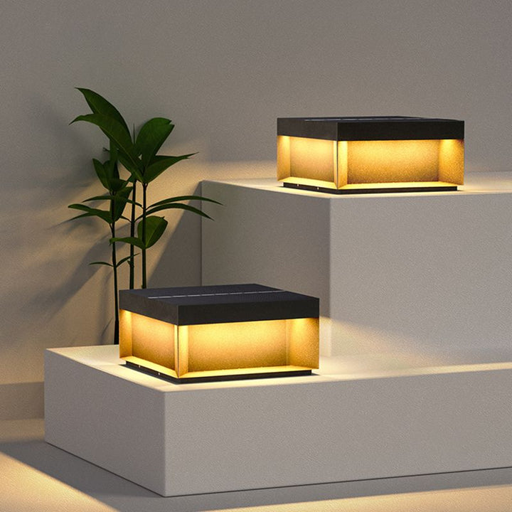 Luz solar de poste LED cálida. Diseño cuadrado moderno, ideal para marcar caminos en jardines con estilo.