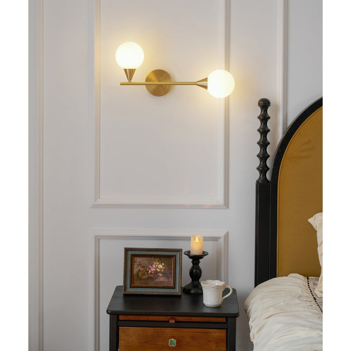 Foco de pared moderno en latón y cristal blanco. Dos globos difusores de luz para el hogar.
