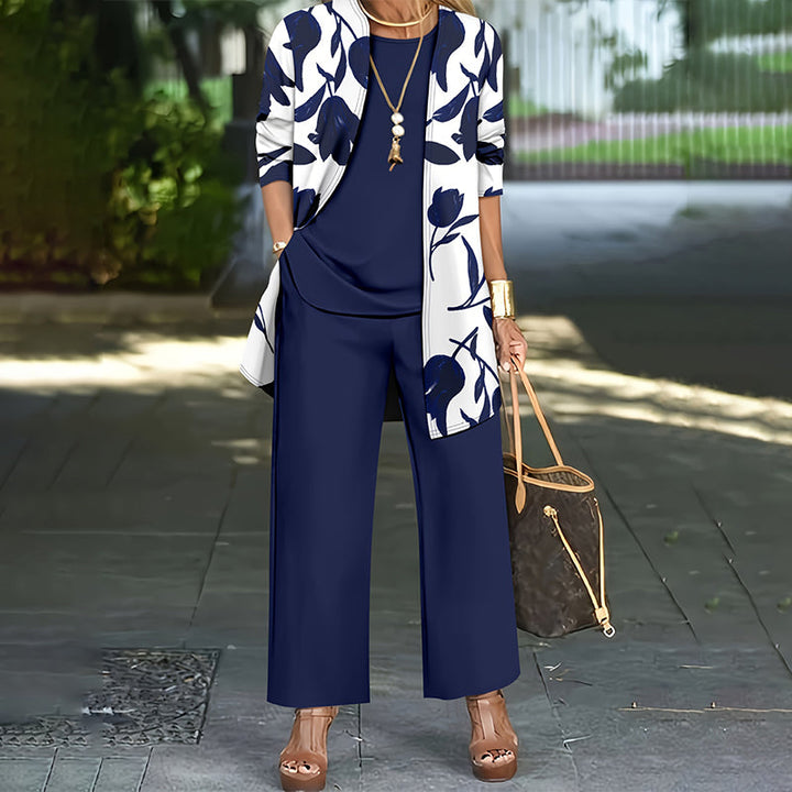Conjunto de tres piezas para mujer con chaqueta floral, pantalón recto y blusa lisa. Estilo casual chic.