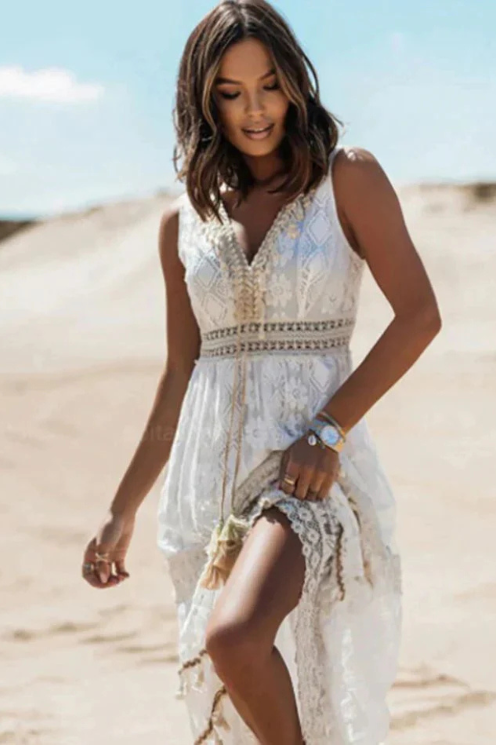 Mujer en vestido maxi bohemio elegante, caminando por la playa, ideal para un estilo veraniego casual y fresco.
