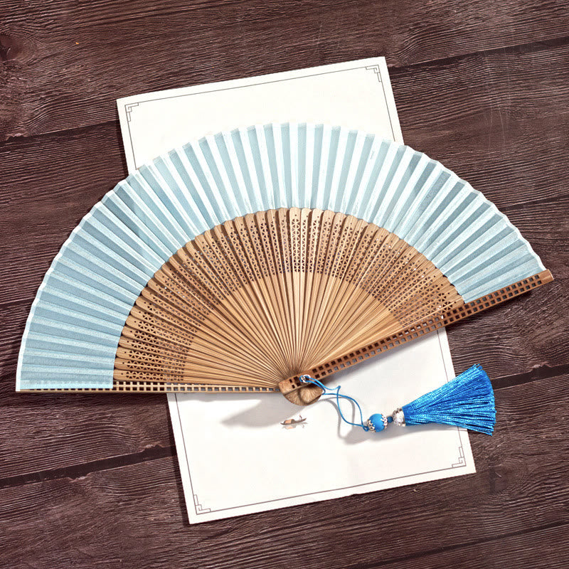 Abanico elegante de seda y bambú, perfecto para mantener la frescura en verano.