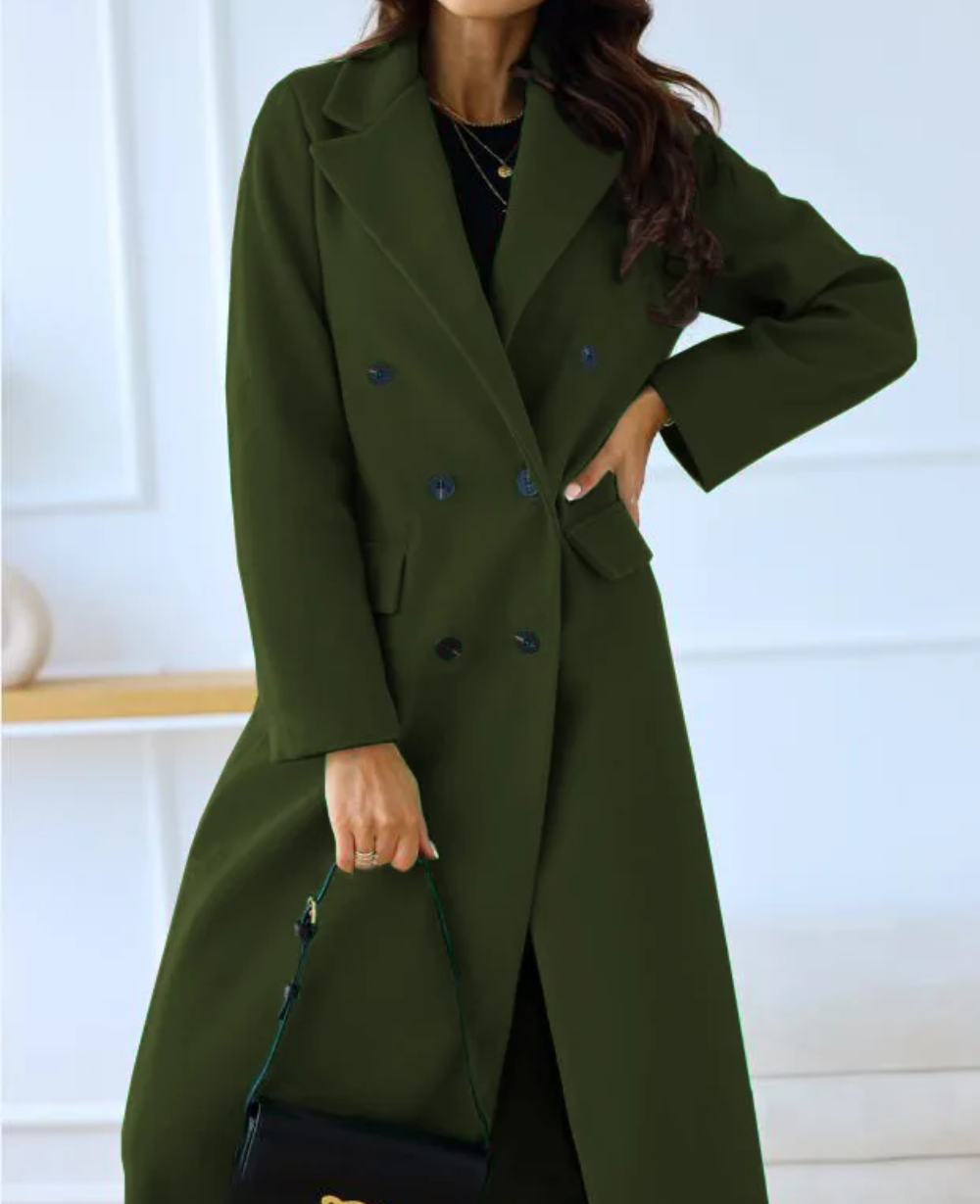 Modelo posando con abrigo largo entallado, doble botonadura, estilo sofisticado para mujer.