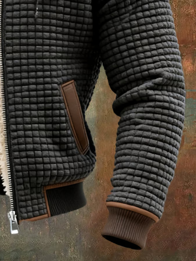 Chaqueta acolchada para hombre en color oscuro con capucha, un abrigo esencial urbano y cálido.