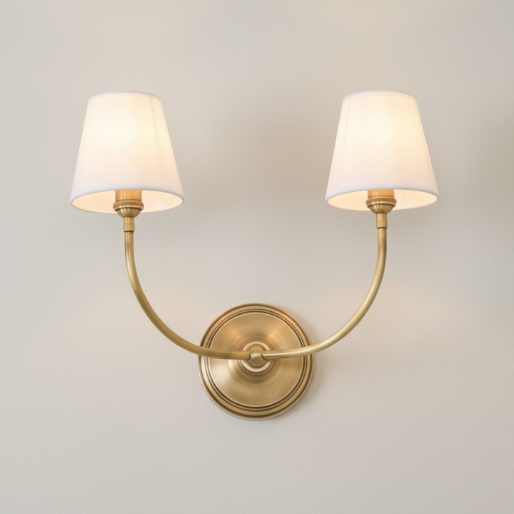 Aplique de pared doble contemporáneo con brazos curvos. Iluminación interior cálida para hogar moderno.