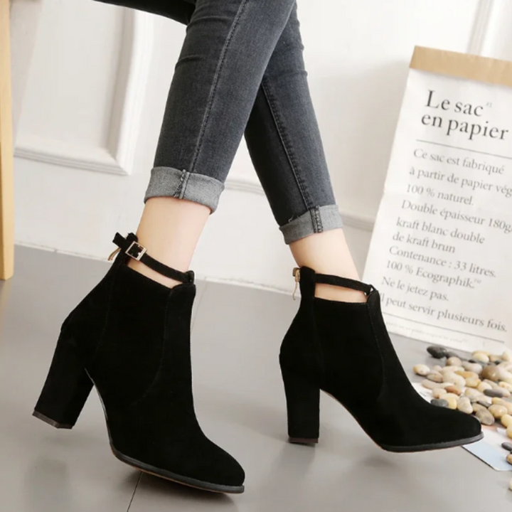 Par de botines negros con tacón bloque, hebilla. Calzado elegante y versátil.