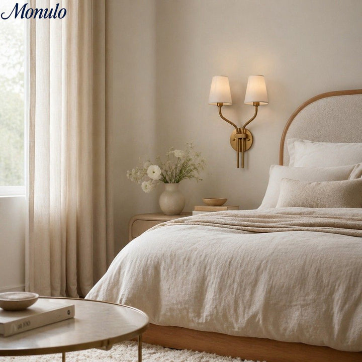 Iluminación dorada cálida para dormitorio de lujo; aplique de pared estilo hotel.