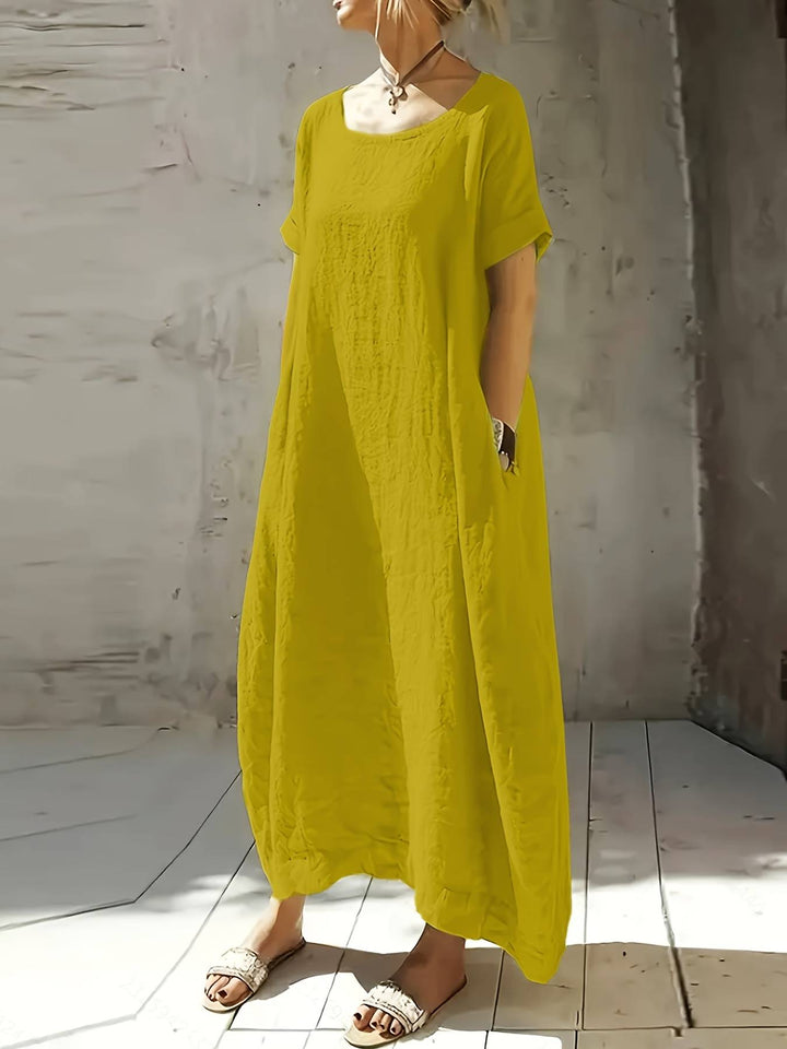 Mujer disfrutando de la comodidad del vestido largo Lola, estilo casual y relajado con mangas amplias para verano.