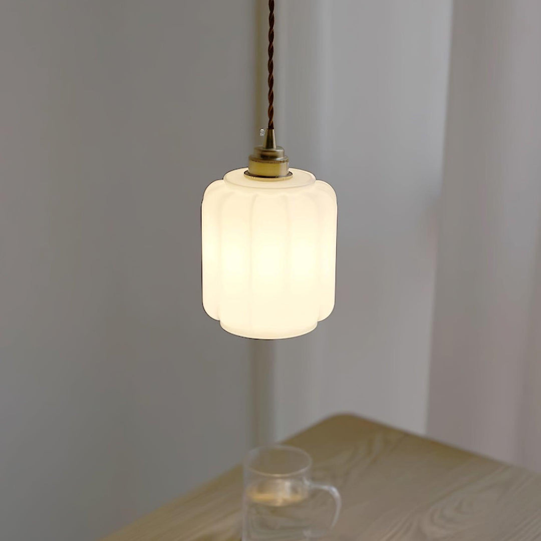Iluminación moderna: lámpara colgante de cristal blanco y latón, diseño minimalista, luz ambiente.