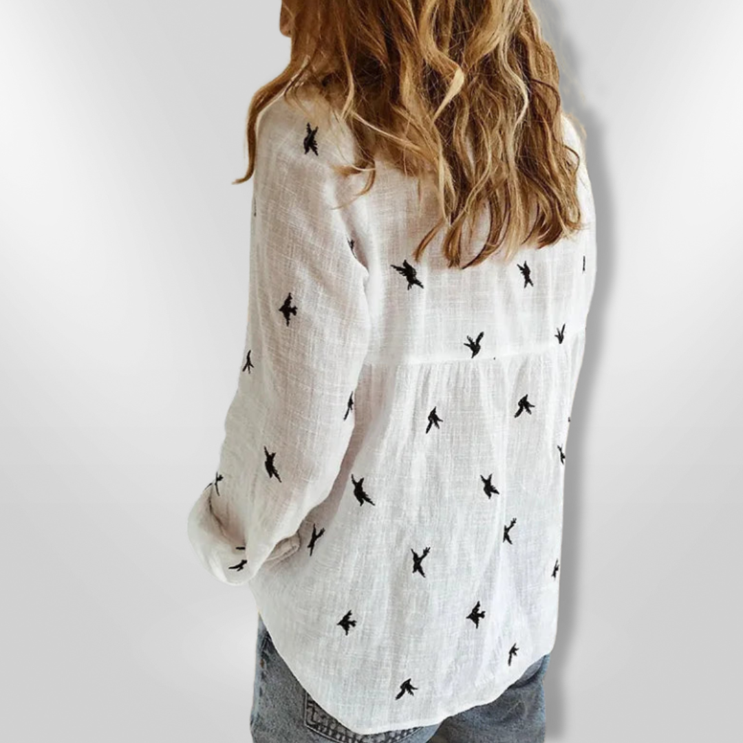 Blusa fresca de mujer con estampado vibrante de aves, diseño de manga larga para moda femenina.