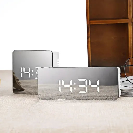 Reloj despertador digital LED con superficie de espejo. Muestra hora y temperatura, ideal para mesita de noche.