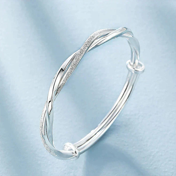 Vista angular de pulsera de plata Elara, joya trenzada para mujer con estética minimalista y chic.