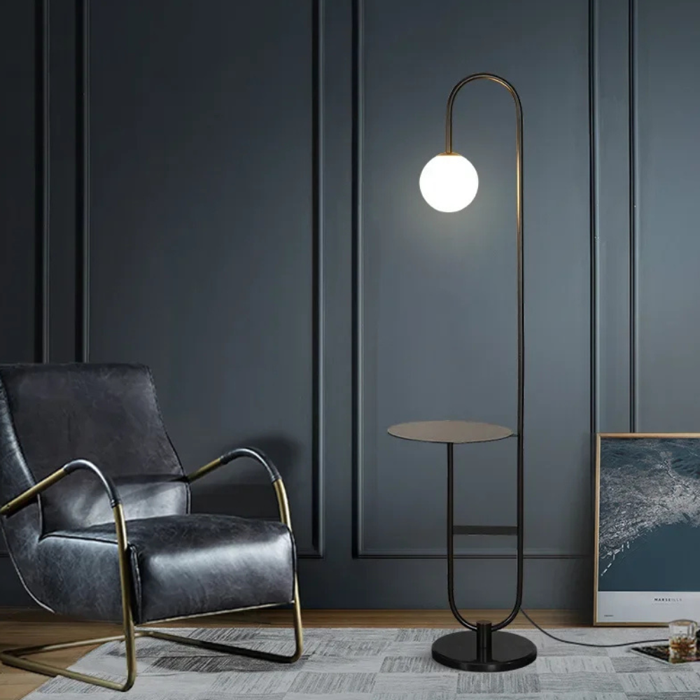 Iluminación ambiental con lámpara de pie negra, mesa integrada; perfecta para sala de estar moderna.