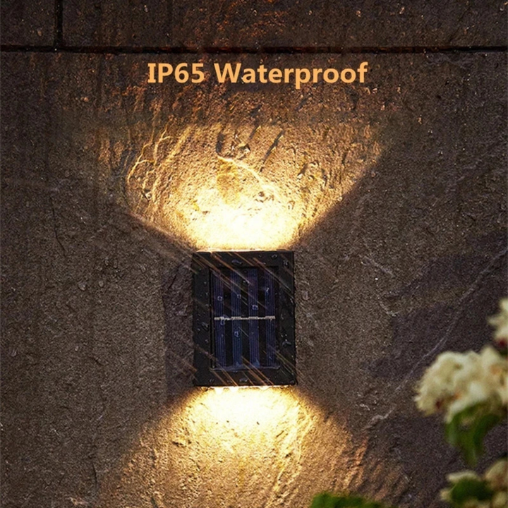 Luz solar LED de pared cargando en el exterior, lista para iluminar el jardín y patio al anochecer.