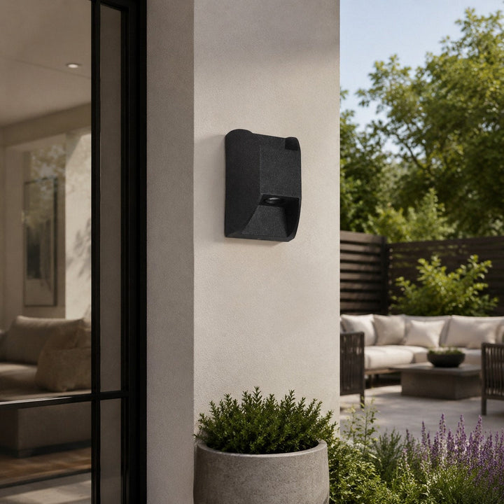 Lámpara exterior LED direccional negra, aplique industrial perfecto para iluminar zonas específicas del jardín.