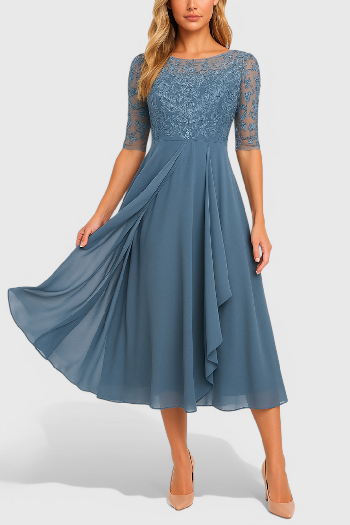 Modelo luciendo vestido midi purpura con bordado delicado y cuello ilusorio, perfecto para celebraciones.