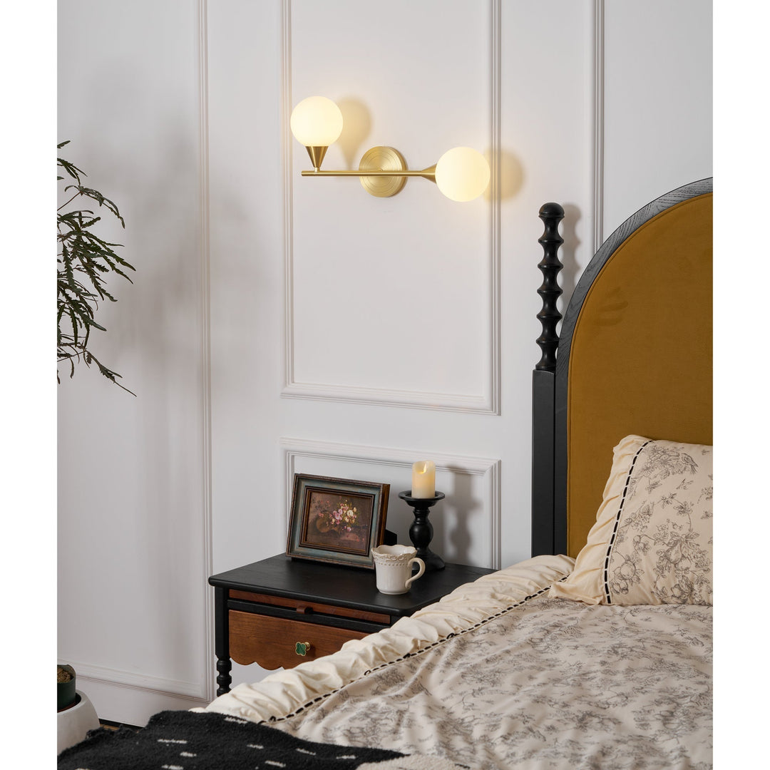 Aplique de pared minimalista. Latón con dos globos de cristal blanco. Iluminación ambiental.