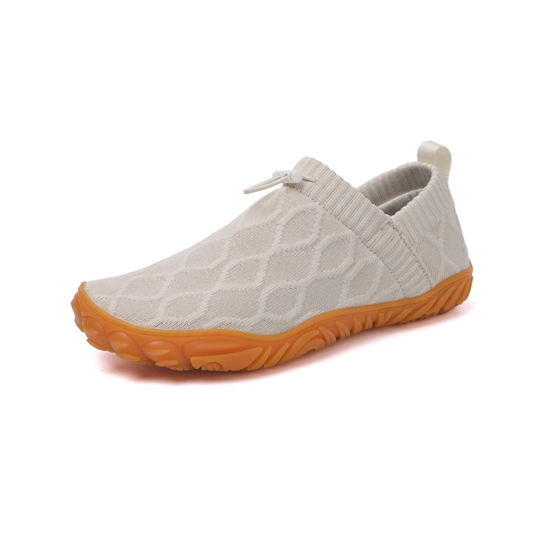 Persona con zapatillas barefoot de senderismo unisex en ruta de montaña. Calzado con puntera ancha y agarre superior.