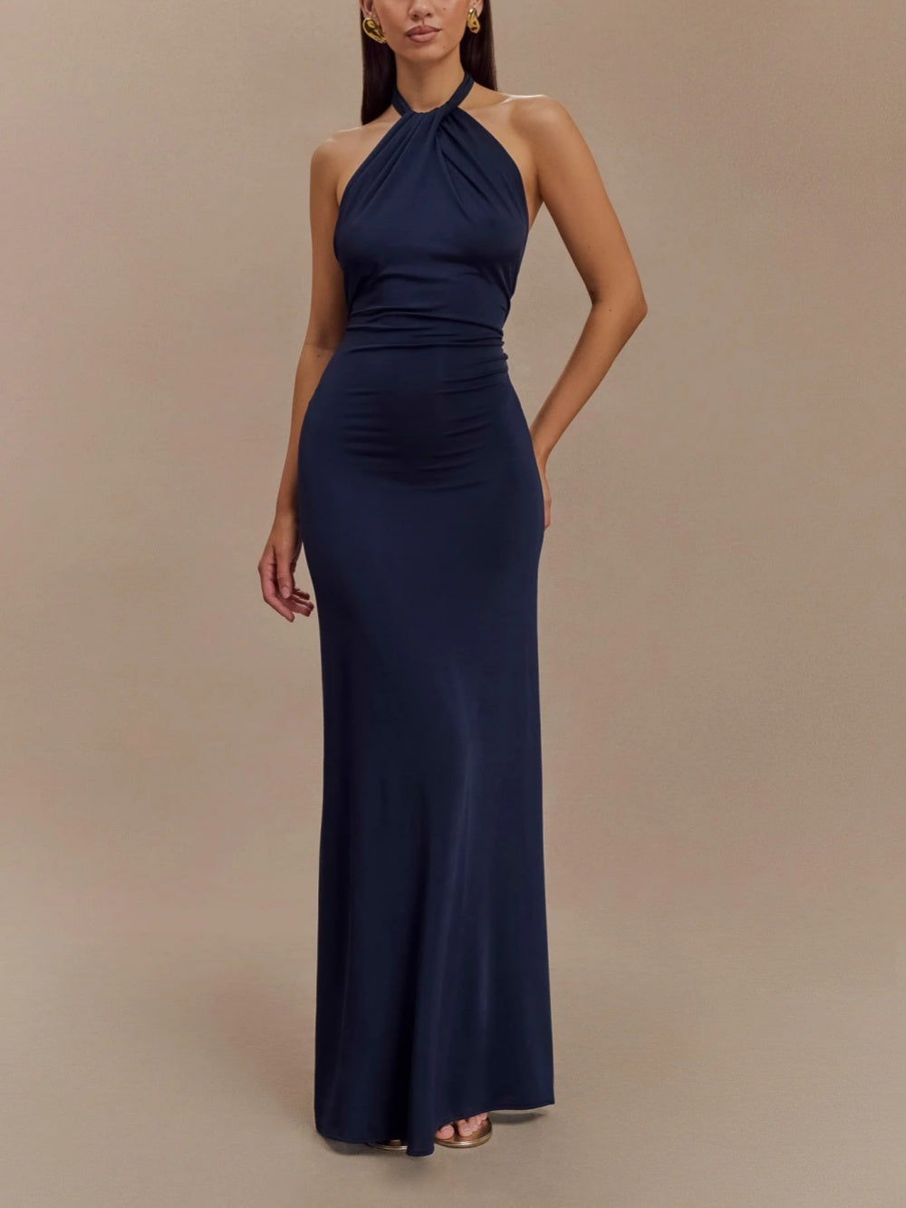 Silueta elegante de vestido largo halter para mujer, con cintura entallada y espalda descubierta. Ideal para ocasiones.