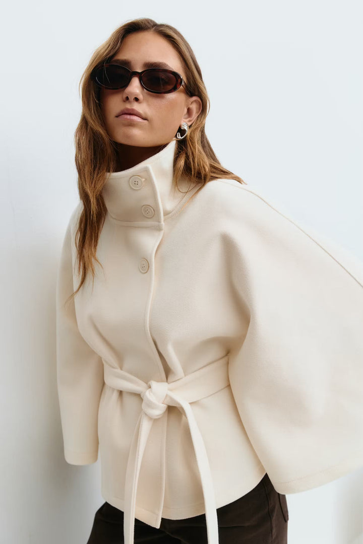 Chaqueta capa elegante para mujer con cuello alto y cinturón. Ideal para moda de invierno.