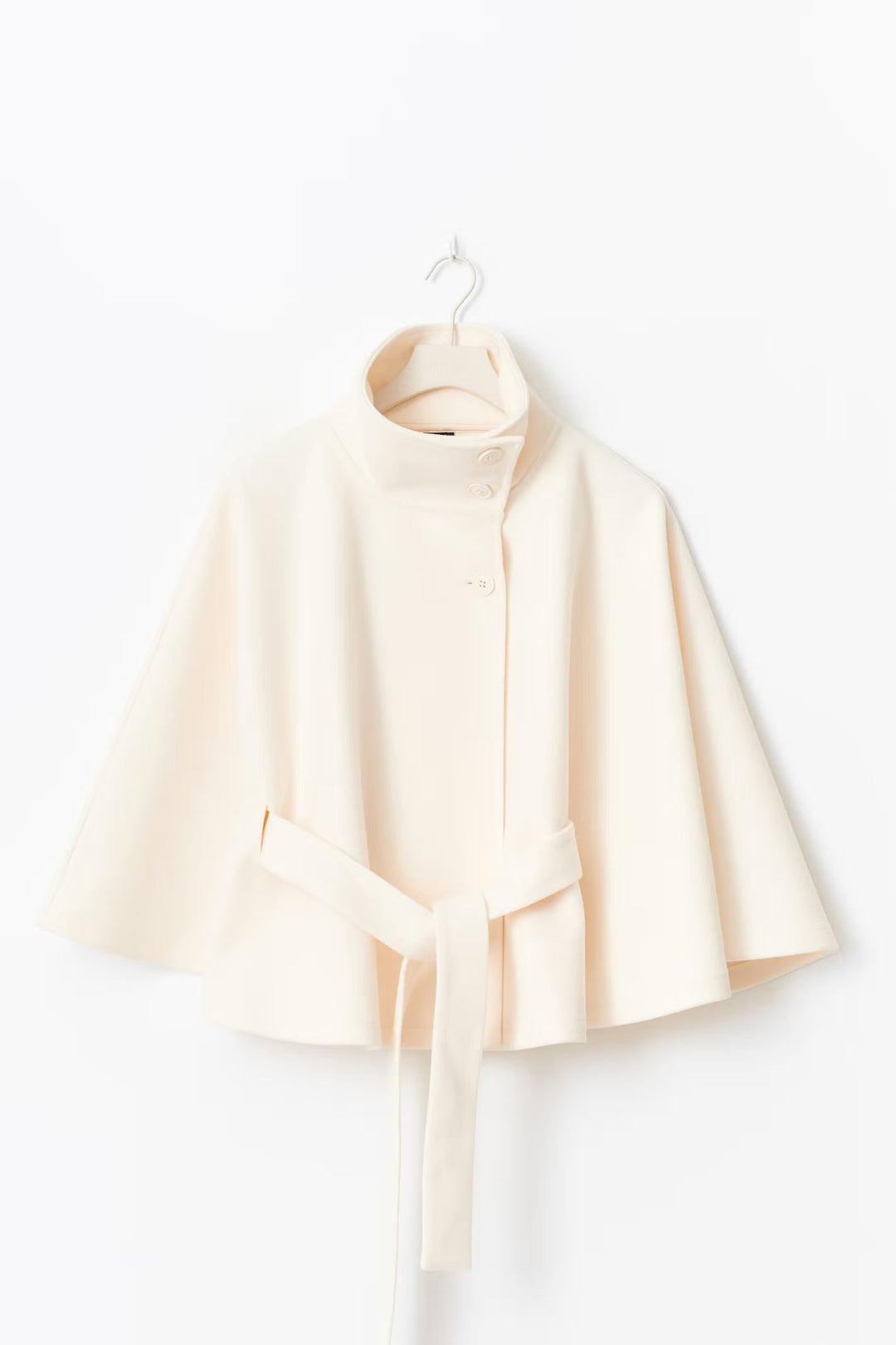 Abrigo de mujer tipo capa, muy elegante con cuello alto y cinturón ajustable. Moda casual y formal.