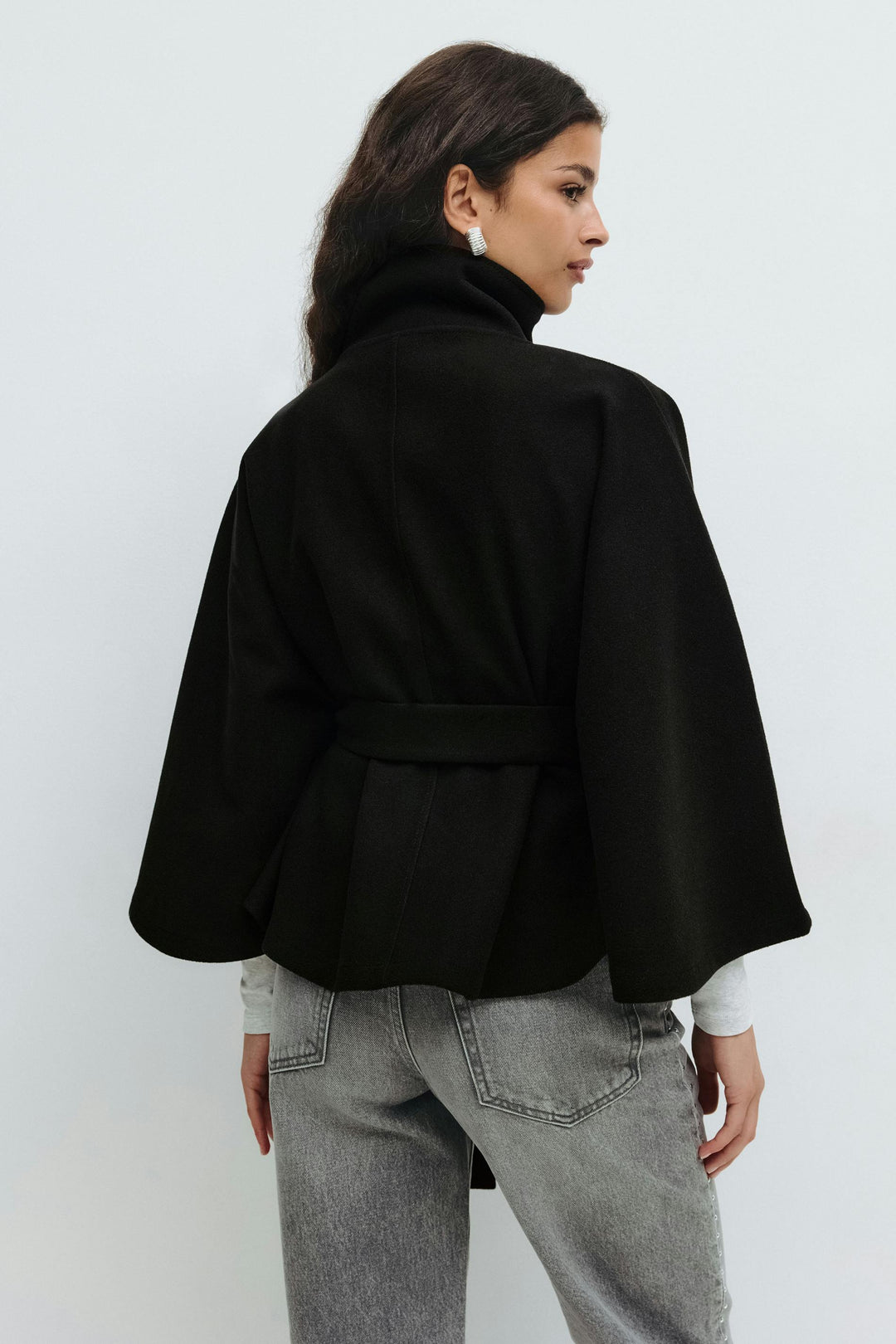 Diseño moderno de chaqueta capa para mujer, con cuello alto y cinturón. Un abrigo elegante para invierno.