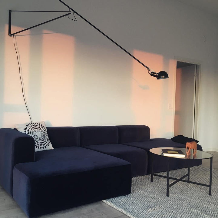 Lámpara de pared industrial negra, con brazo articulado ajustable para iluminación funcional.