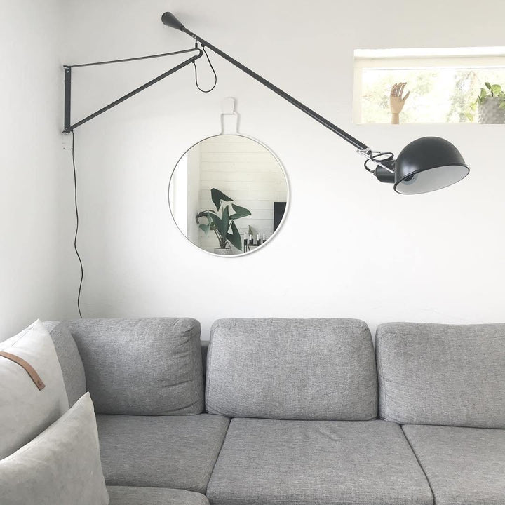 Aplique de pared industrial ajustable blanco, perfecto para crear ambiente en sala de estar.