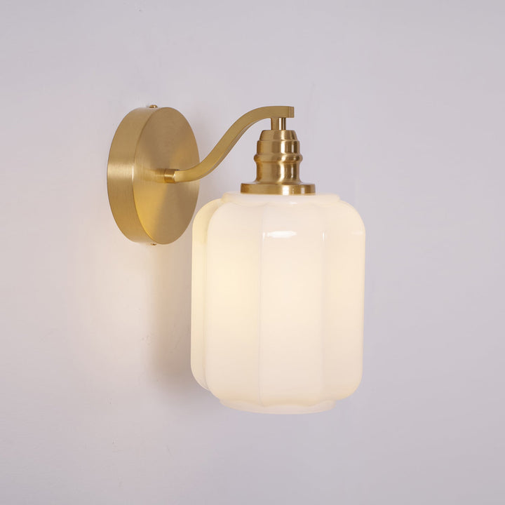 Lámpara de pared compacta de latón y cristal, apta para ambientes marinos.