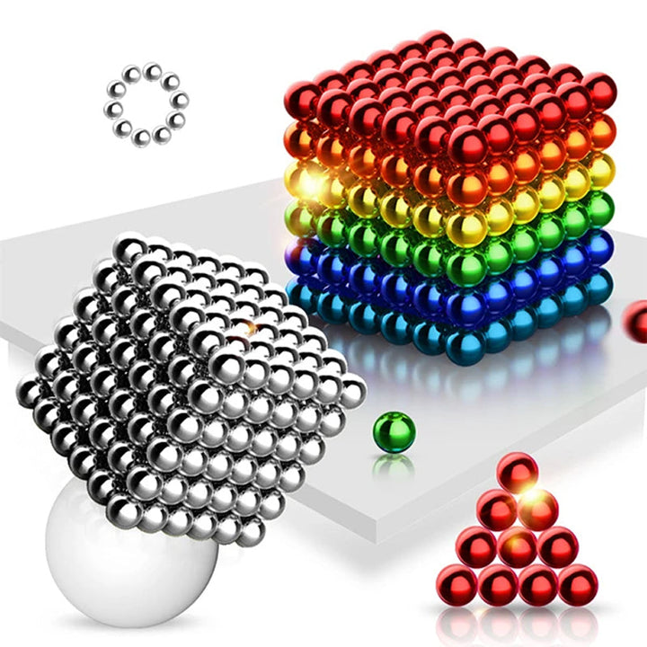 Manos creando una estructura compleja con bolas magnéticas. Fomenta el diseño, la habilidad manual y la concentración.