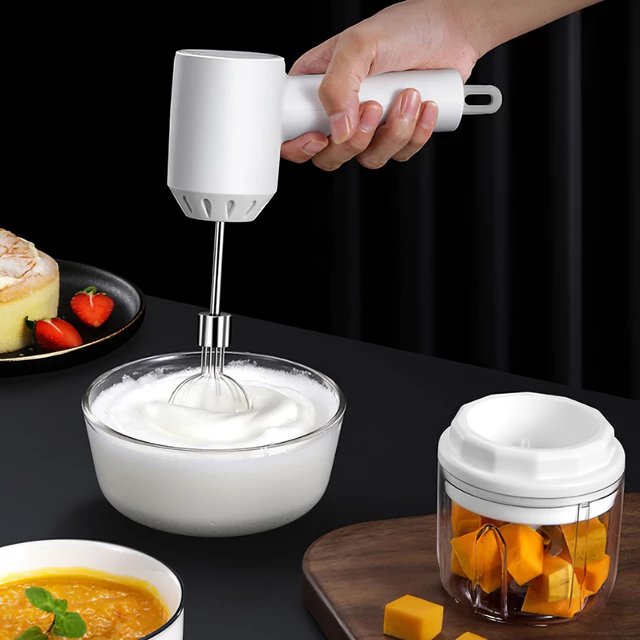 Picadora eléctrica inalámbrica procesando verduras frescas. Ideal para picar carne o hierbas en la cocina.