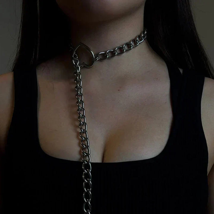 Primer plano de collar gótico punk con colgante de corazón. Detalle de joyería alternativa para mujer, accesorio de declaración.