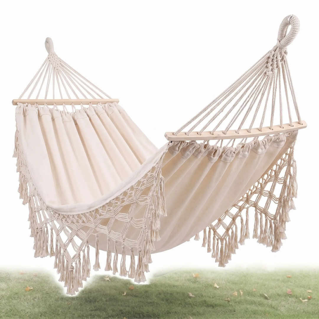 Hamaca de lona doble con barra, blanca y con flecos. Ideal para el jardín y camping, ofrece máximo confort.