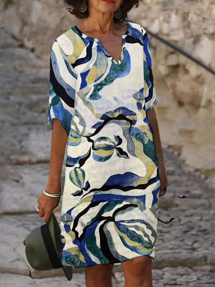 Vestido estampado abstracto azul de verano para mujer. Diseño moderno con escote en V, perfecto para un look casual fresco.