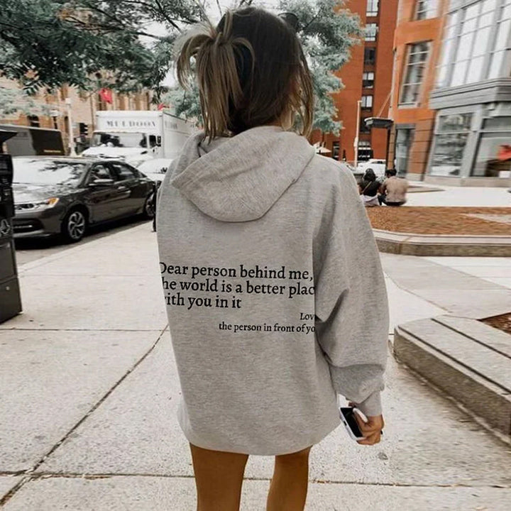 Mujer sonriente luciendo sudadera SNOW blanca. Hoodie pullover cómodo y abrigador para ropa de invierno.