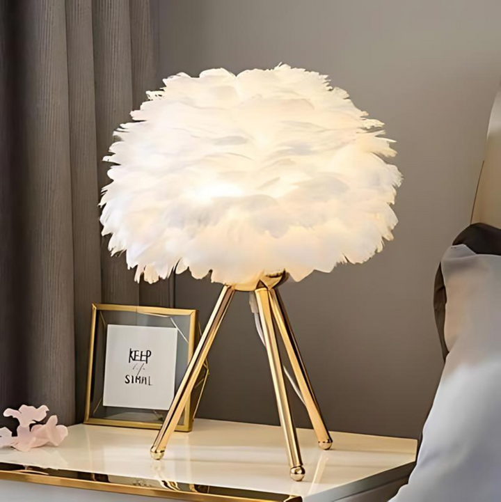 Lámpara de mesa con plumas blancas y luz cálida LED, perfecta para decorar salón y dormitorio.