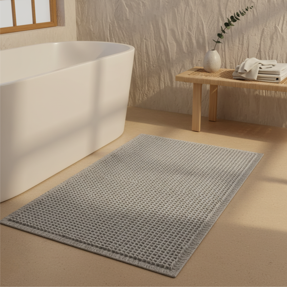 Alfombra de baño super absorbente para confort de pies. Diseño waffle con borlas decorativas.