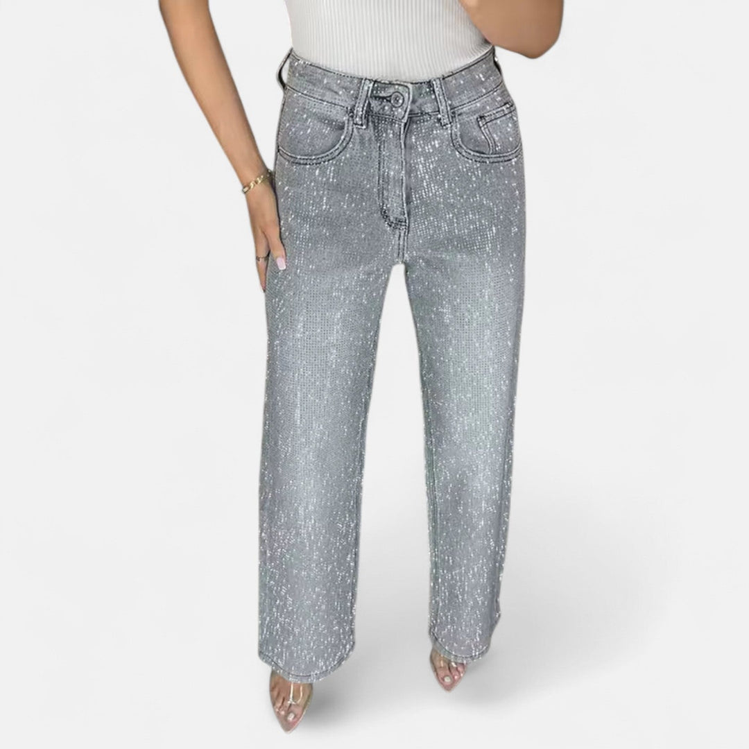 Jeans denim de mujer con detalles de pedrería y silueta de pierna ancha, ideales para moda cómoda.